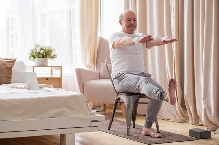 Man sitting on chair doing exercises