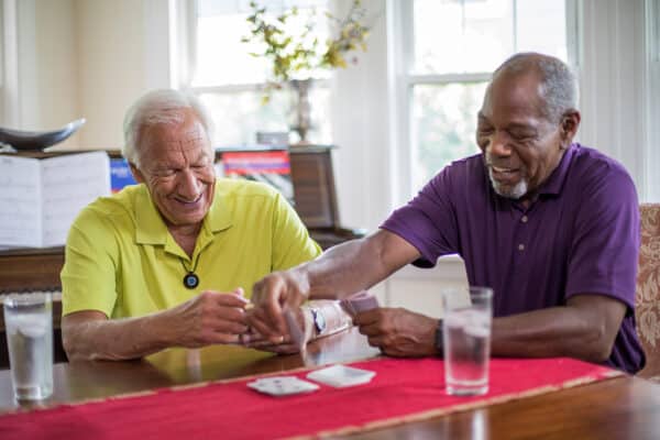 Man with HomeSafe Cellular playing cards with a friend