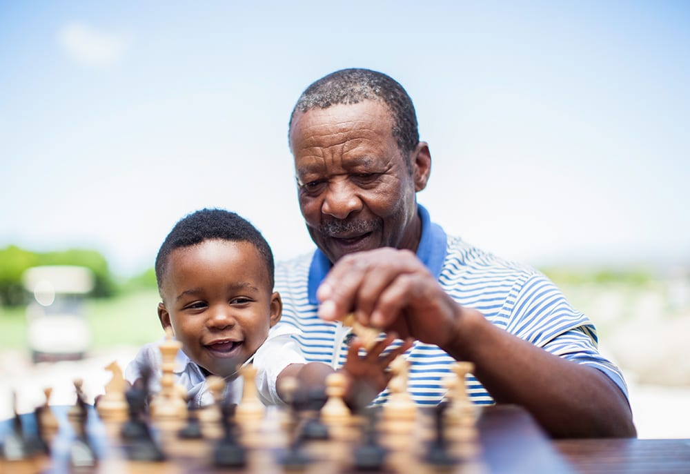 Grandfather Playincg Chess with Grandchild - 1000x687