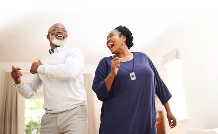 Senior couple dancing and wearing On the Go medical alert system