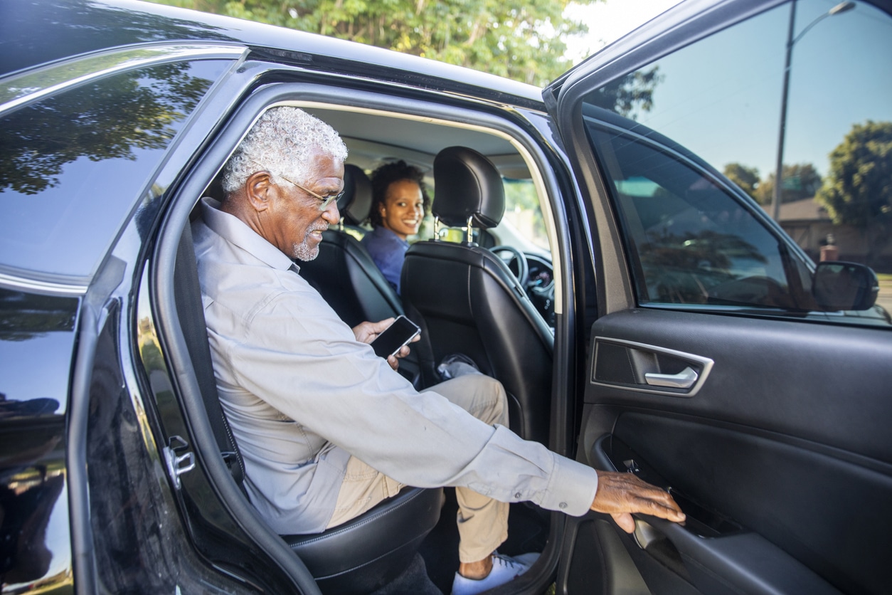 Senior man getting into a car