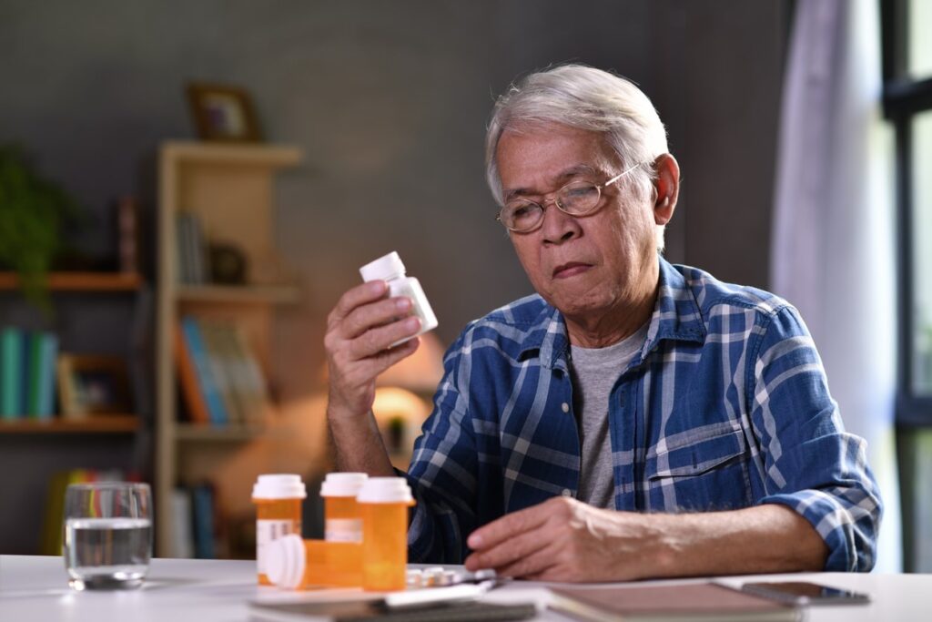Depression in older adults. Asian senior man with his medicine bottles