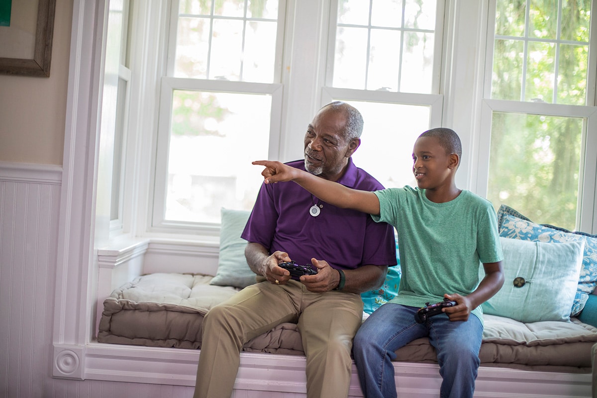 grandfather wearing HomeSafe playing video games with grandson