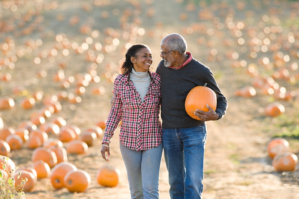 Older couple walking through a pumpkin patch