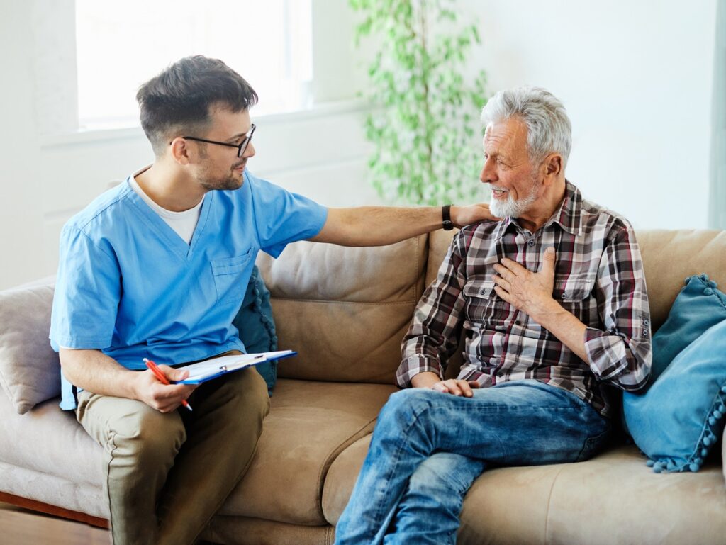 Senior-sitting-on-couch-with-nurse