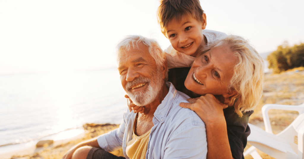 Grandparents enjoying time with their grandson outdoors by the water on National Grandparents Day