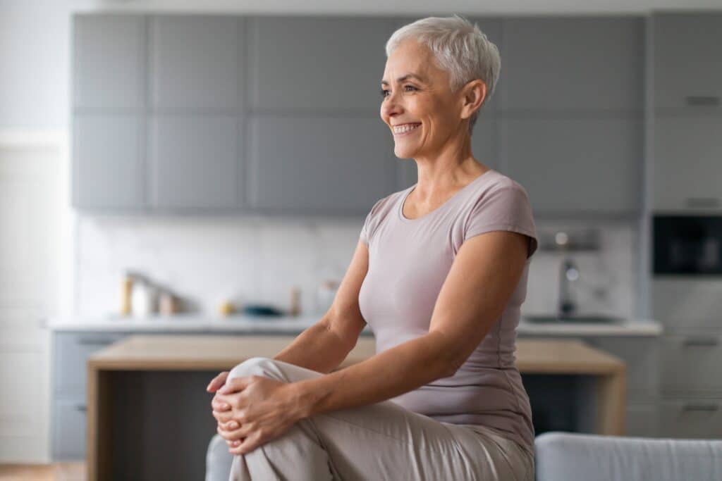 Senior woman practicing seated side stretches at home as part of core exercises for seniors.