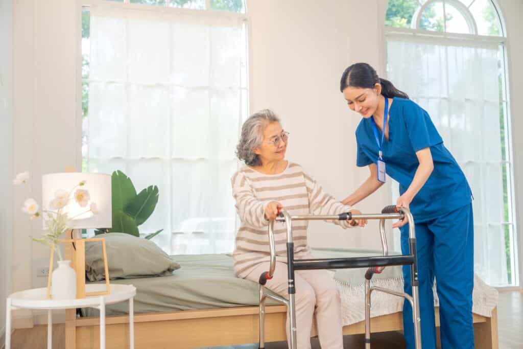 Caregiver assisting an older woman with a walker for fall prevention for seniors.